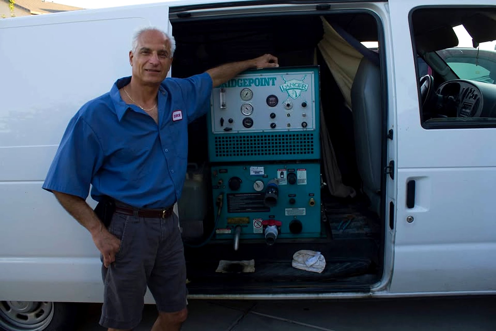 George Ghafari standing by his white van and truck-mounted cleaning machine