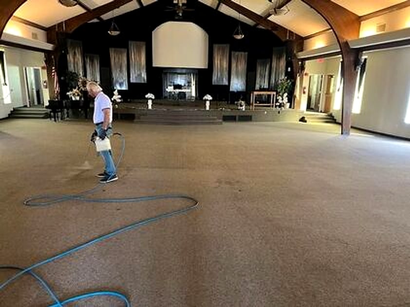 George steam cleaning the carpet of a church hall